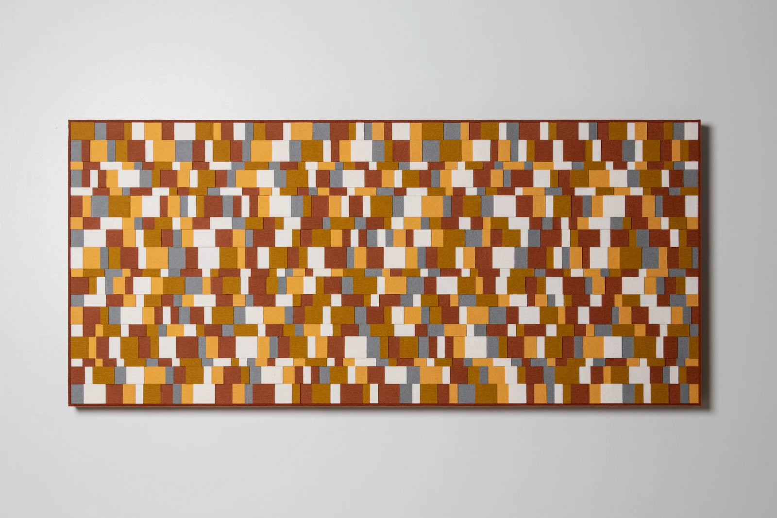 An Aerial wall panel. A rectangular wall art with multicolor white, yellow, gray, and rust felt in various sizes and layers.
