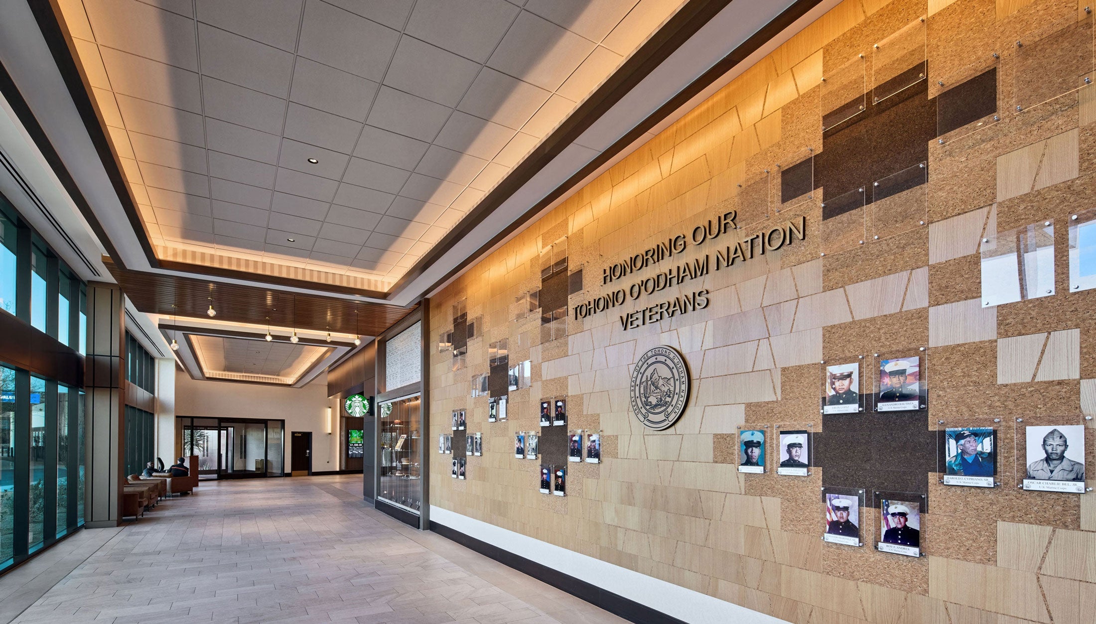 Interior hallway with a wall featuring a plaque and framed photos on wood wall