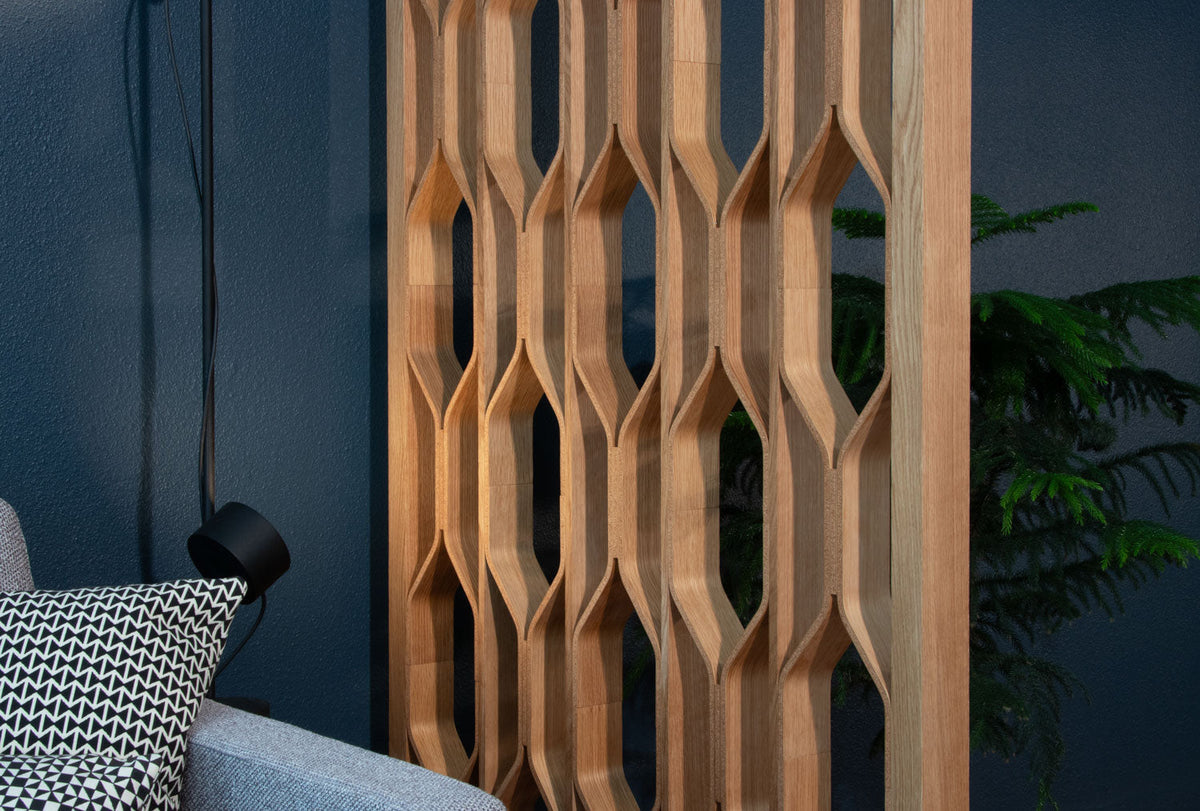 A dimensional wood wall covering in white oak with the shadow of palm leaves on it