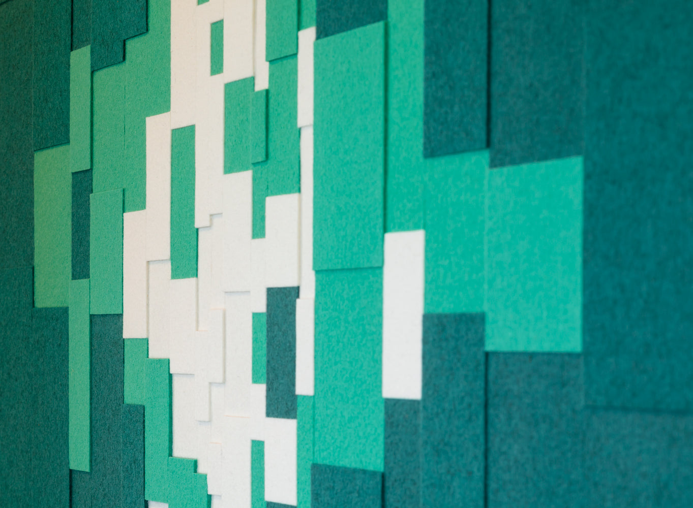 Closeup of blue, green, and white felt blocks in various sized overlaping.