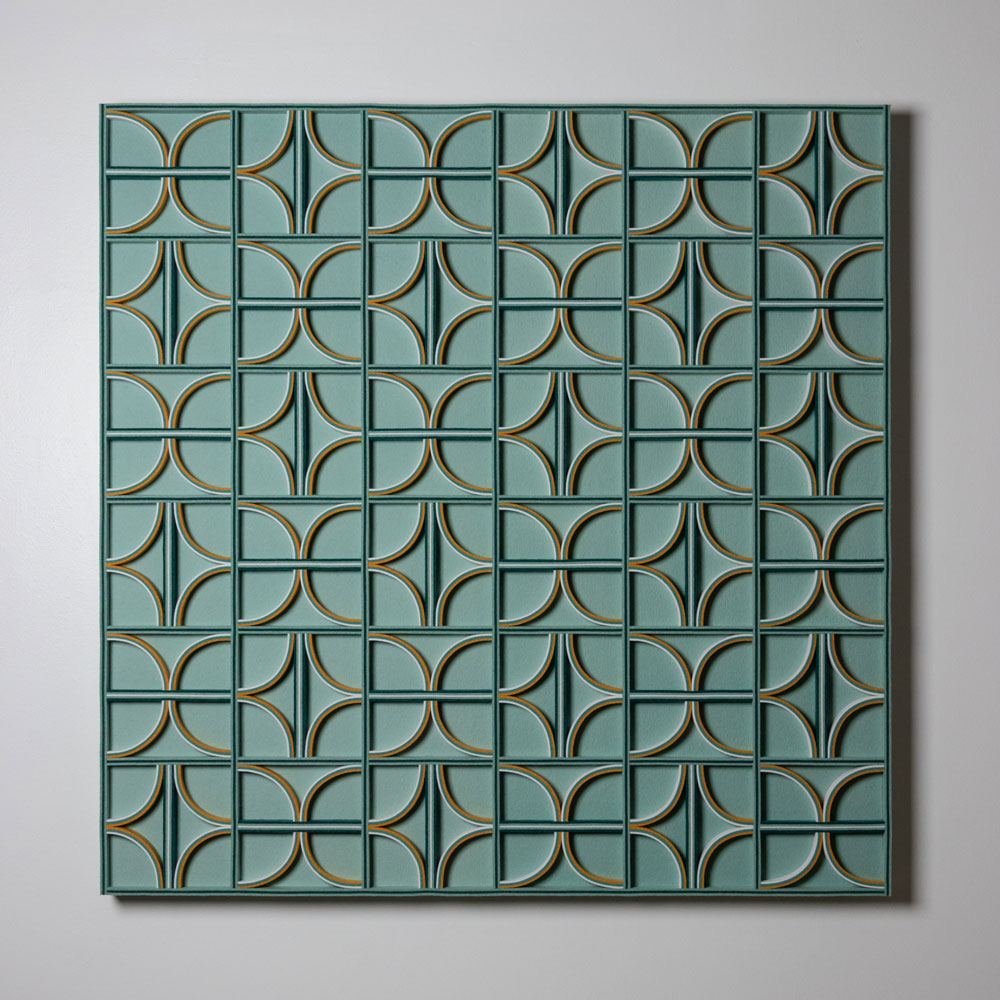 Patterned felt wall art with curved and straight felt details on edge. The background is a teal or sage color, and the details are yellow, white, teal, and dark green. 