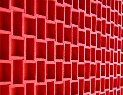 Closeup of red felt panel with grid pattern seen at angle