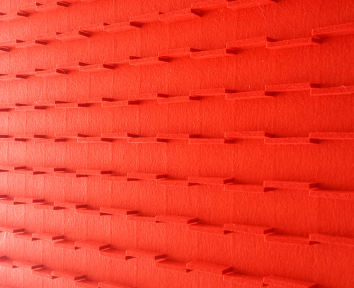 Red felt tabs on a red felt background seen at an angle