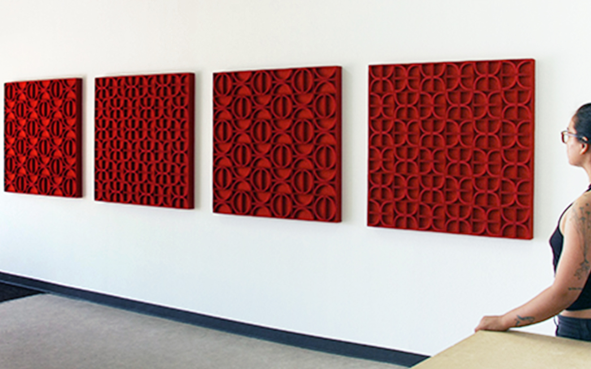 Four square red felt wall panels with different patterns