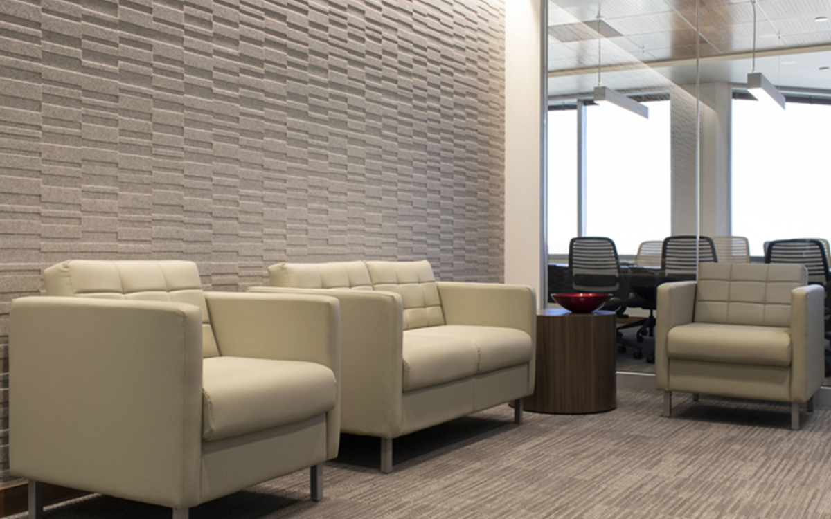 Heathered white felt wall covering in a lobby area with large chairs.