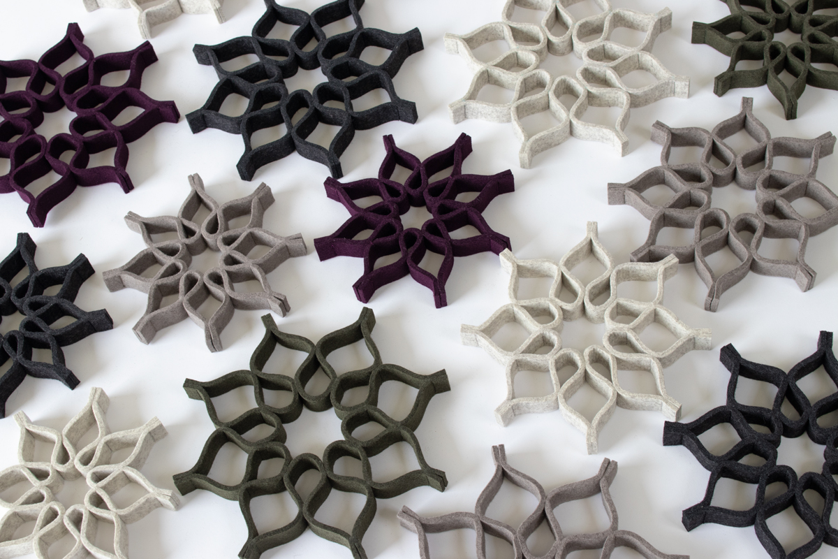 Trivets with a curved star or snowflake shape in grays and purple.