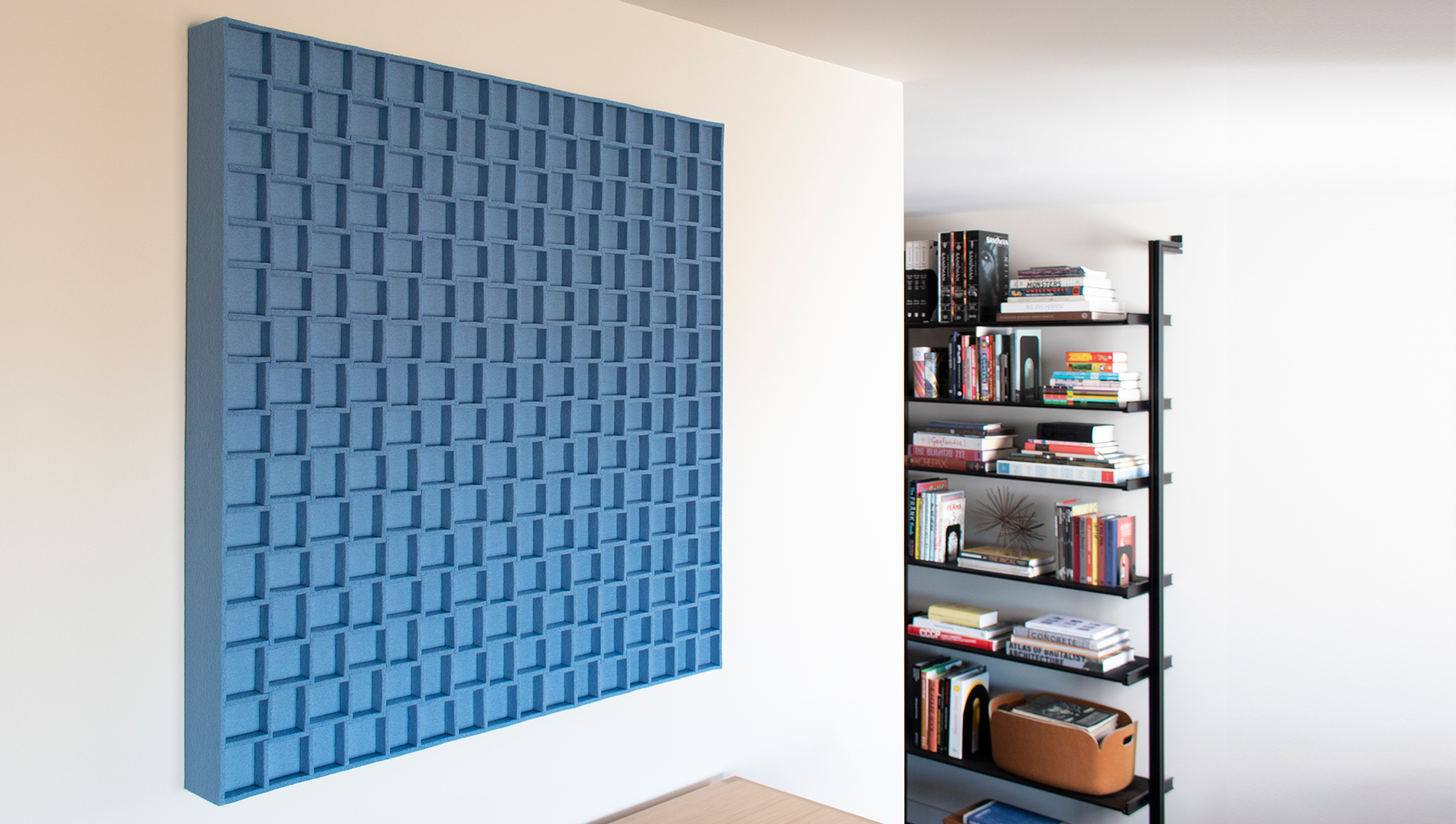 Submaterial Odessa wall decor panel in sky blue hangs in a home library
