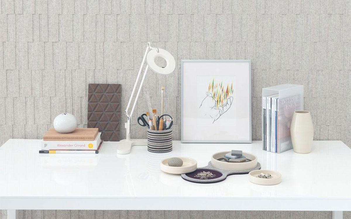 a white desk with a modern folk ware desk set and lamp. Behind the desk is submaterial index dimensional wallcovering