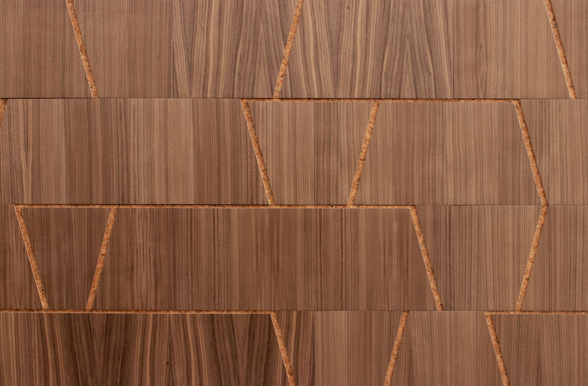 Closeup of wood wall covering in walnut and cork with notched out angled lines