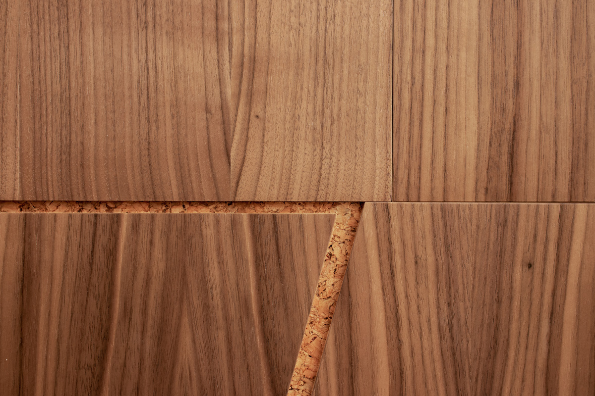 Extreme closeup of wood wall covering in walnut and cork with notched out angled lines
