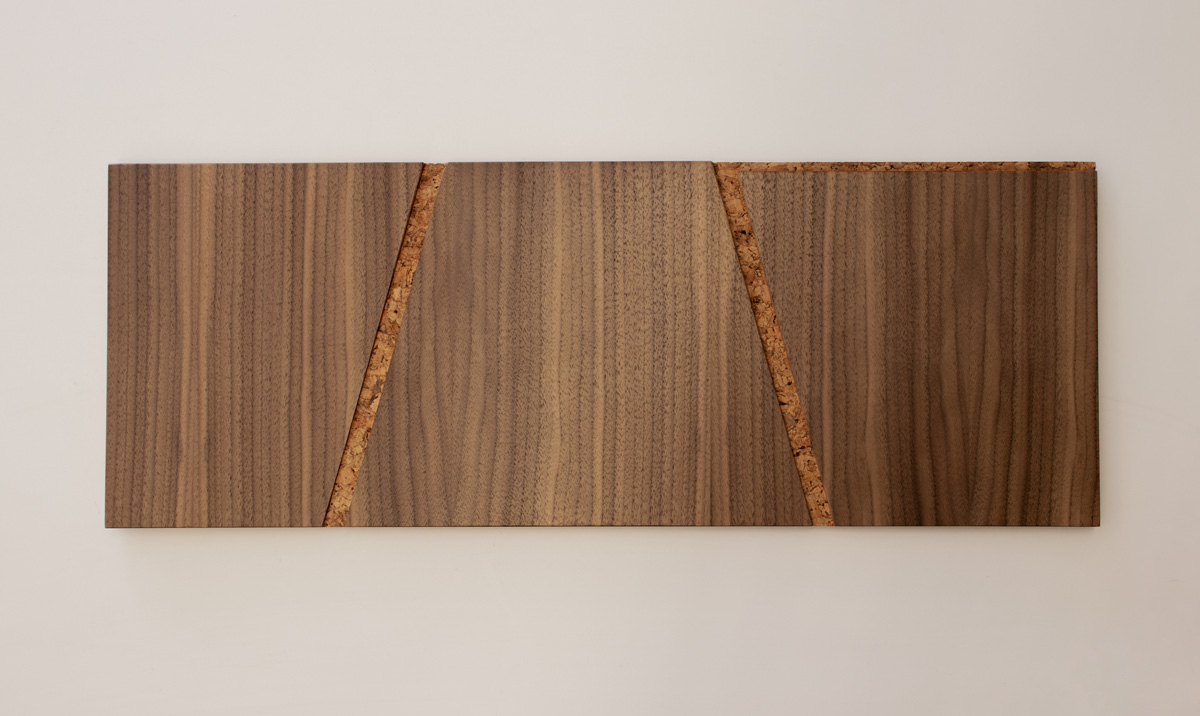 A tile of a wood wall covering in walnut and cork with notched out angled lines