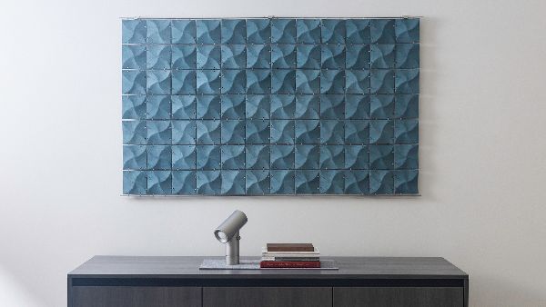 Rectangular blue Ultrasuede wall hanging. Small squares with a subtle pinwheel pattern are connected together with metal rings.