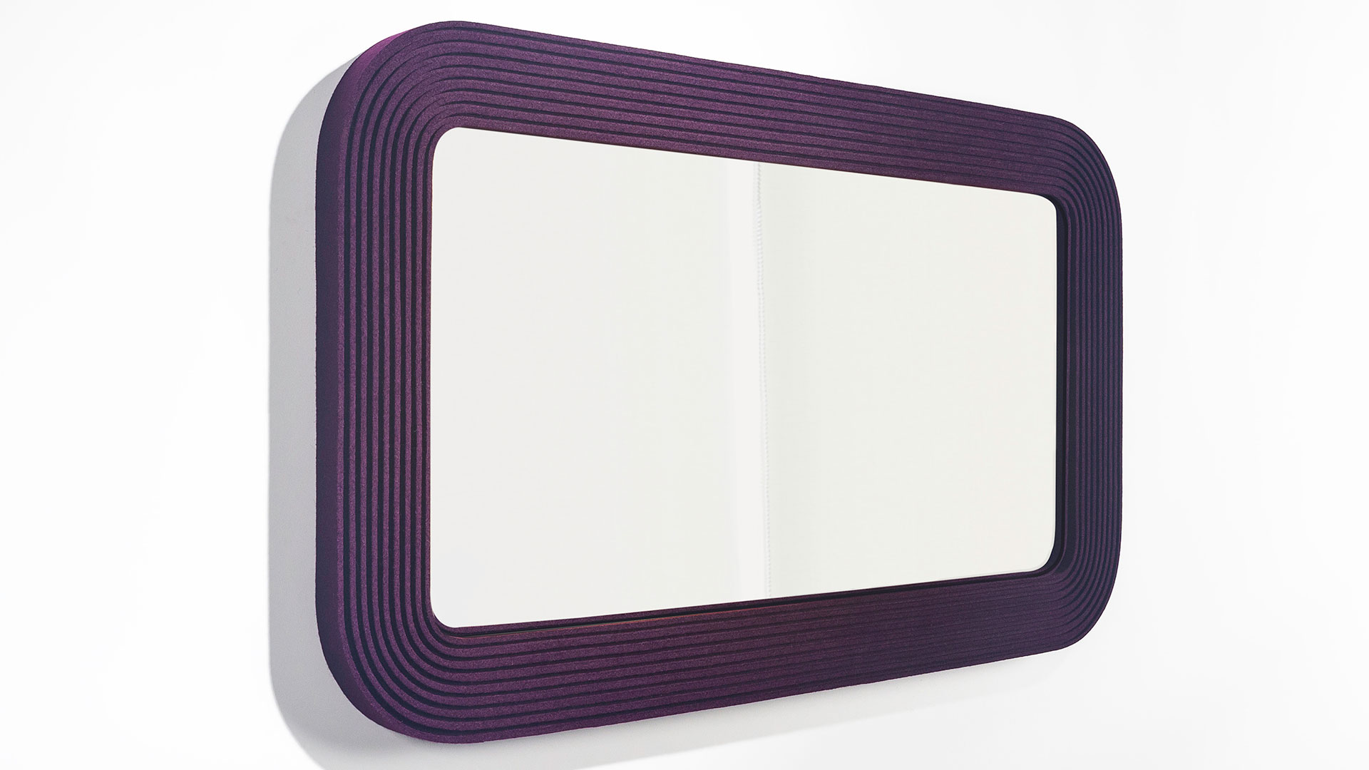 A rectangle mirror framed with deep red/purple ribbed felt hung horizontal