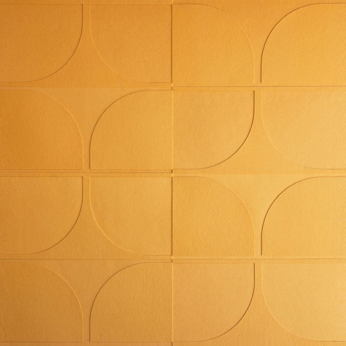 A closeup of muted orange felt wall covering with quarter circle patterns.