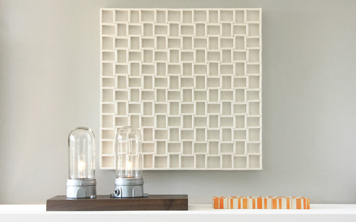 Square felt wall panel with a grid-like pattern.