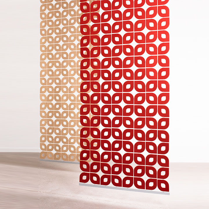 One tan and one red felt screen in an open petal shaped pattern hang in a white space.