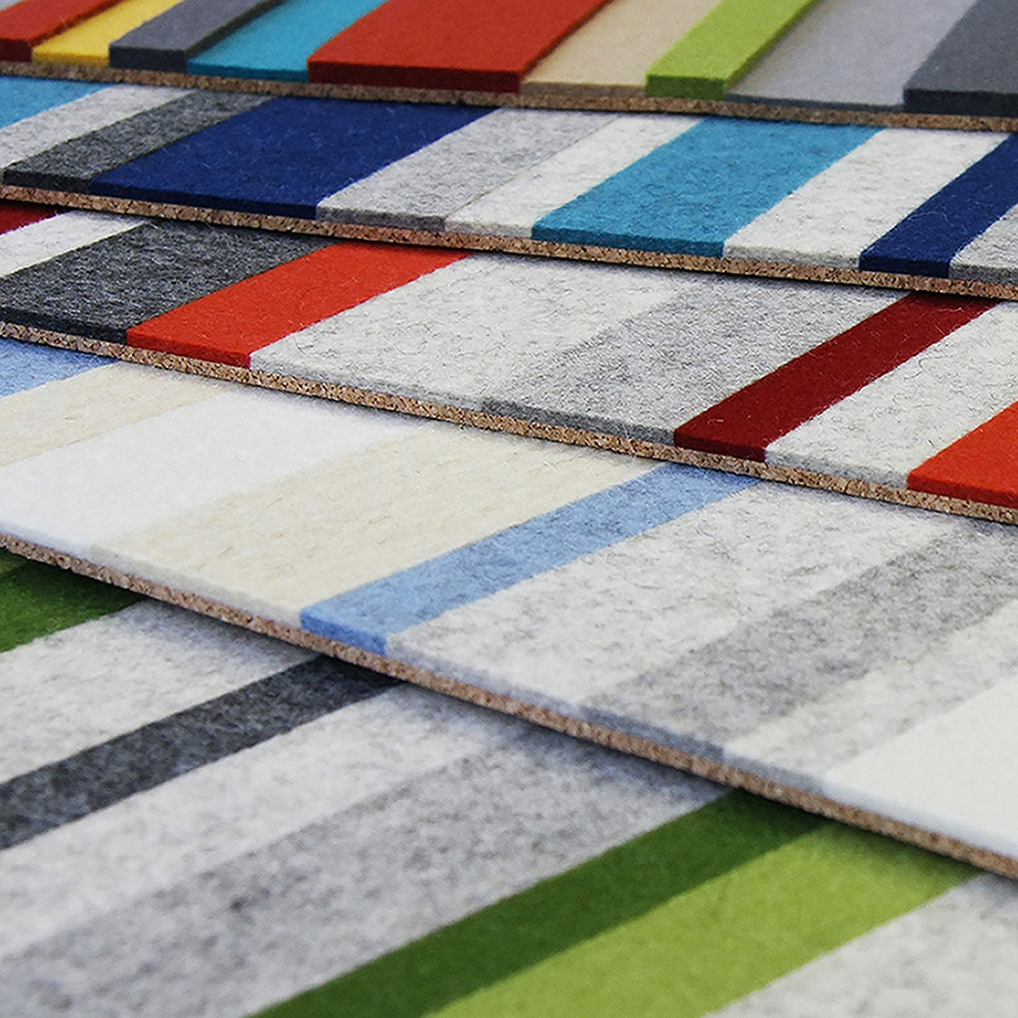 Sheets of colorblocked felt in grays, blues, and reds attached to a cork backing.