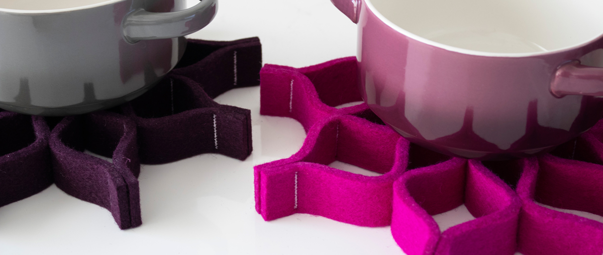 Purple and pink felt trivets with pots sitting on them