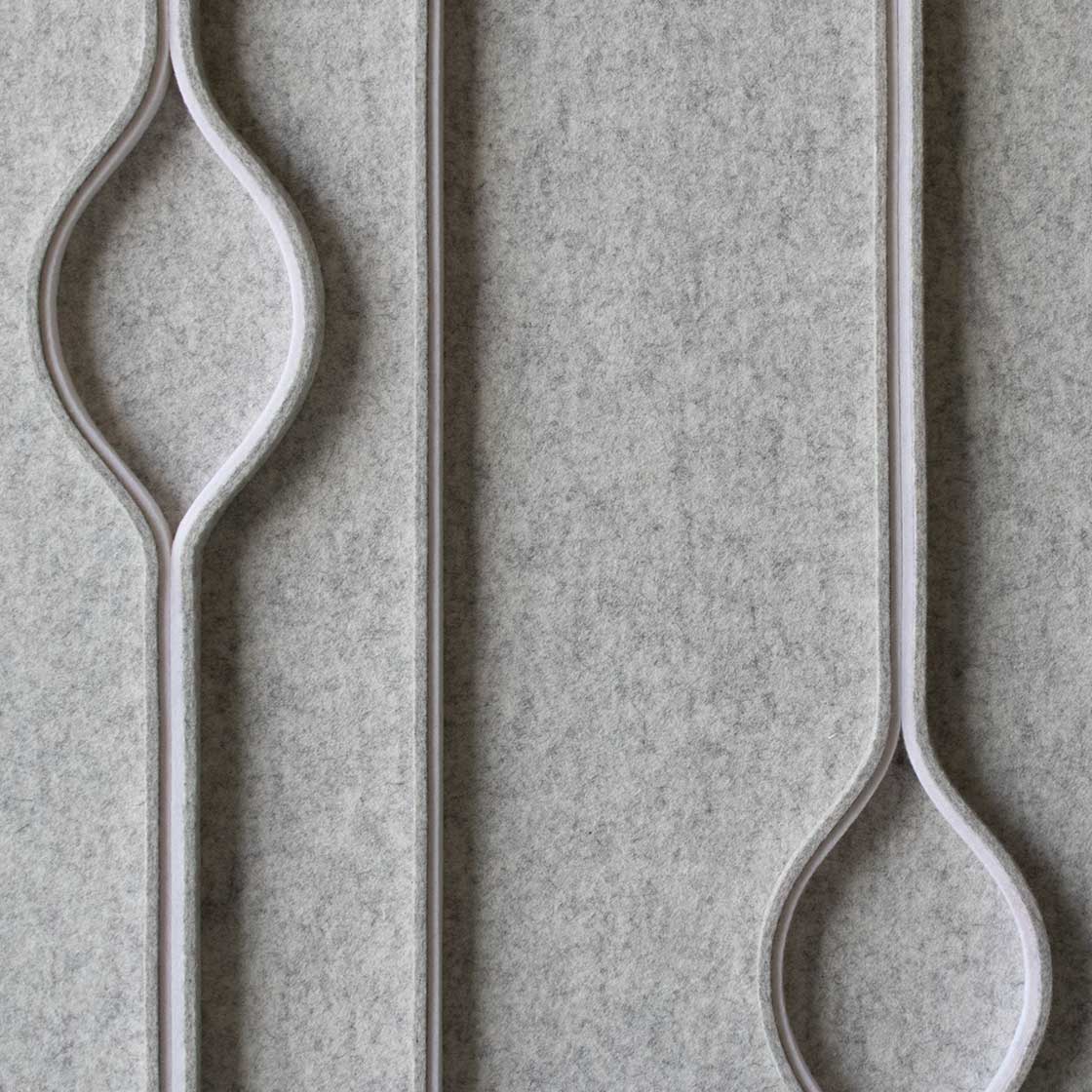 Close up of light gray wall covering with vertical lines and occasional raindrop shapes