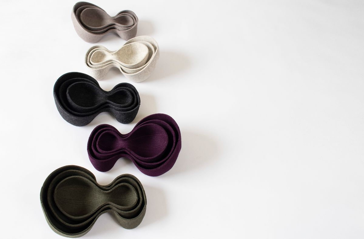 Wool bowls with organic peanut shapes in colors of gray and purple.