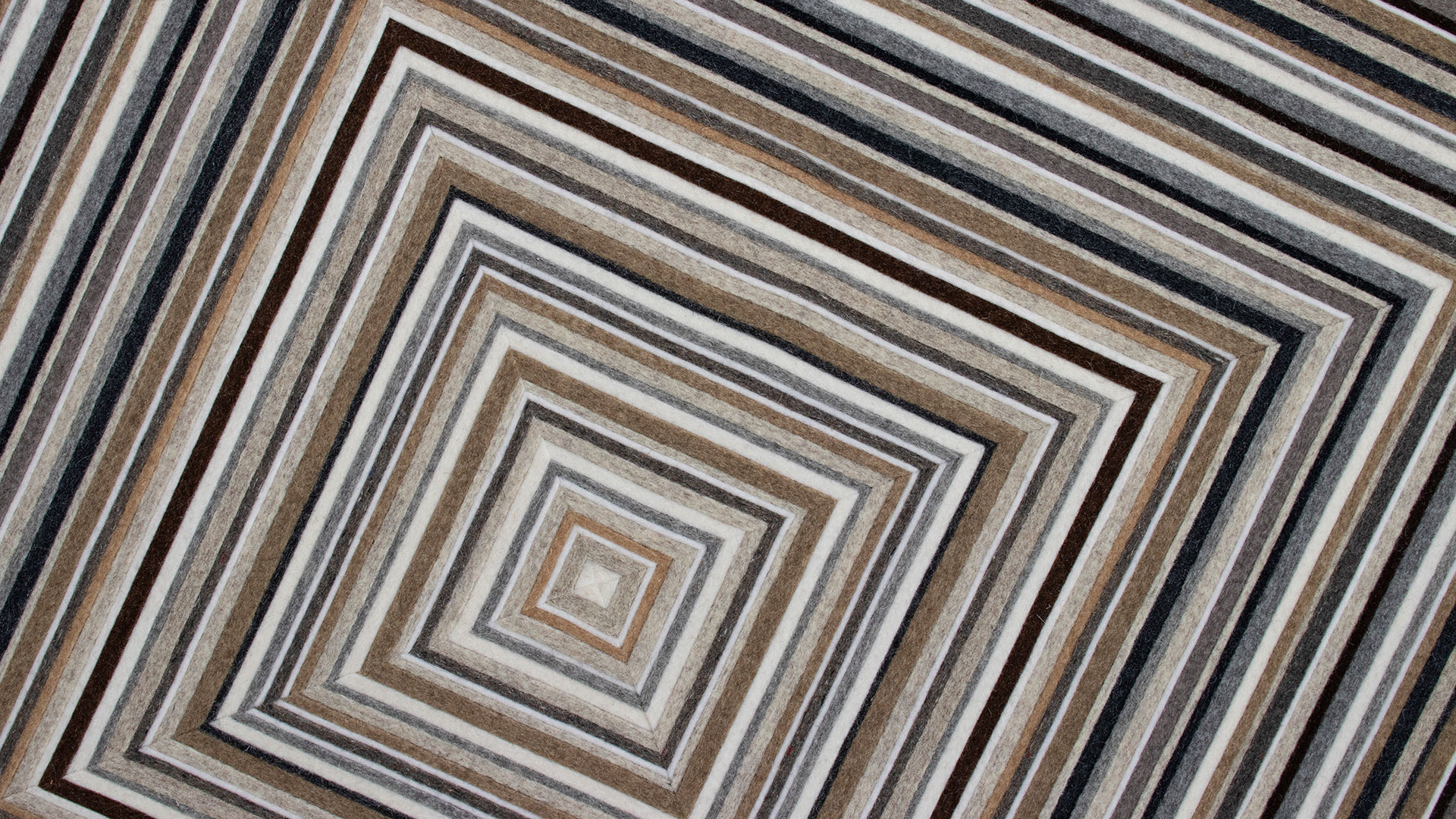 Closeup of the center of a wall panel with a brown and gray concentric square pattern