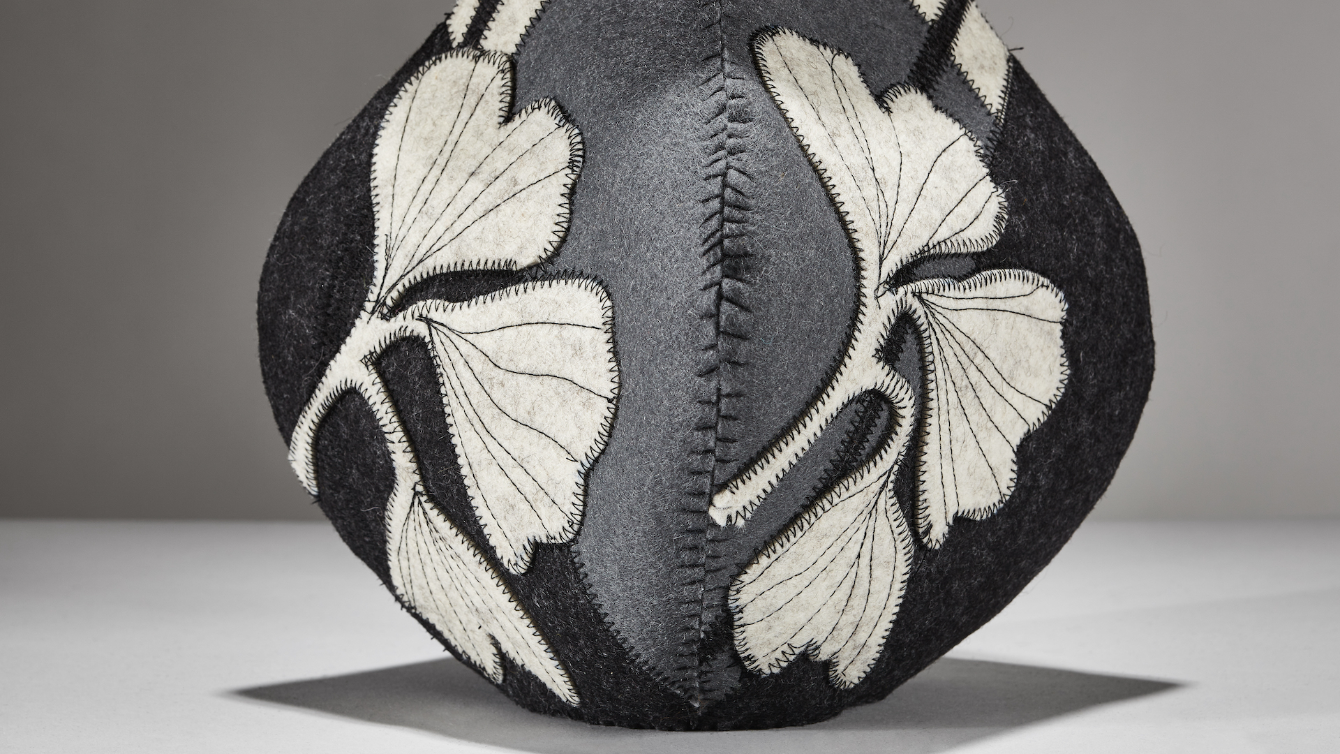 closeup of hand sewn wool vessel made by new mexico artist molly zimmer featuring a ginkgo leaf