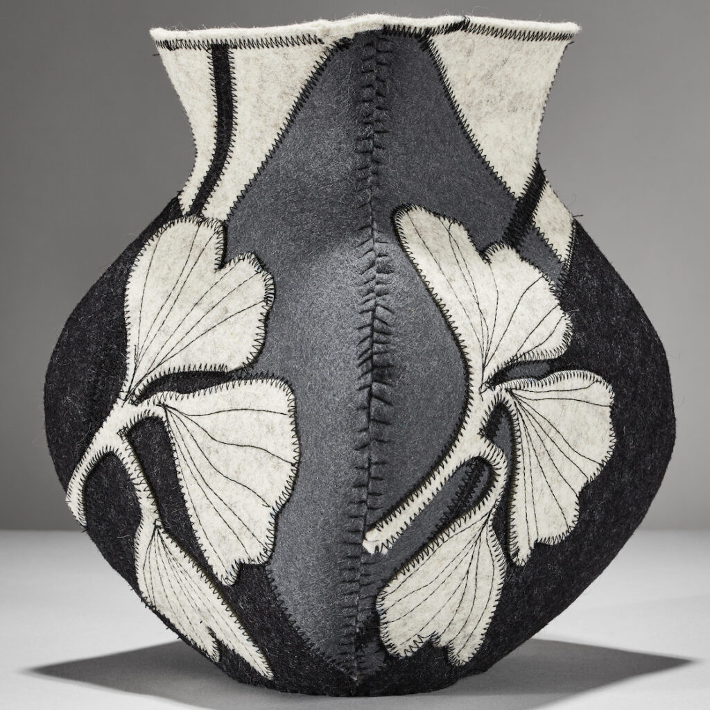 gray neutral vessel made from wool felt with a ginkgo leaf emblem