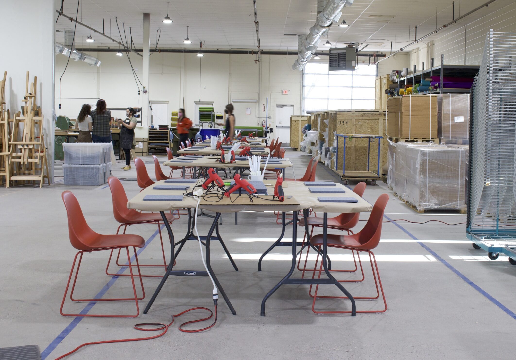 tables set up with orange chairs in a large production space