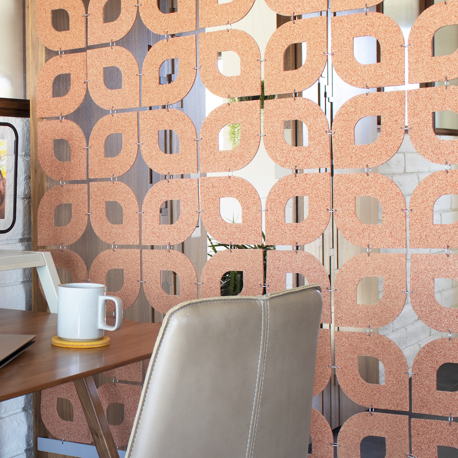 Red cork screen in petal-like pattern next to a busy home desk.