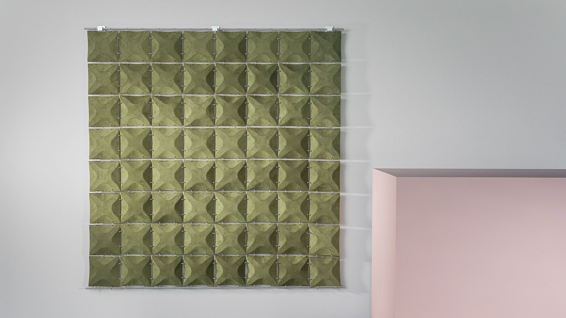 Moss green suede dimensional wall hanging connected by metal rings.