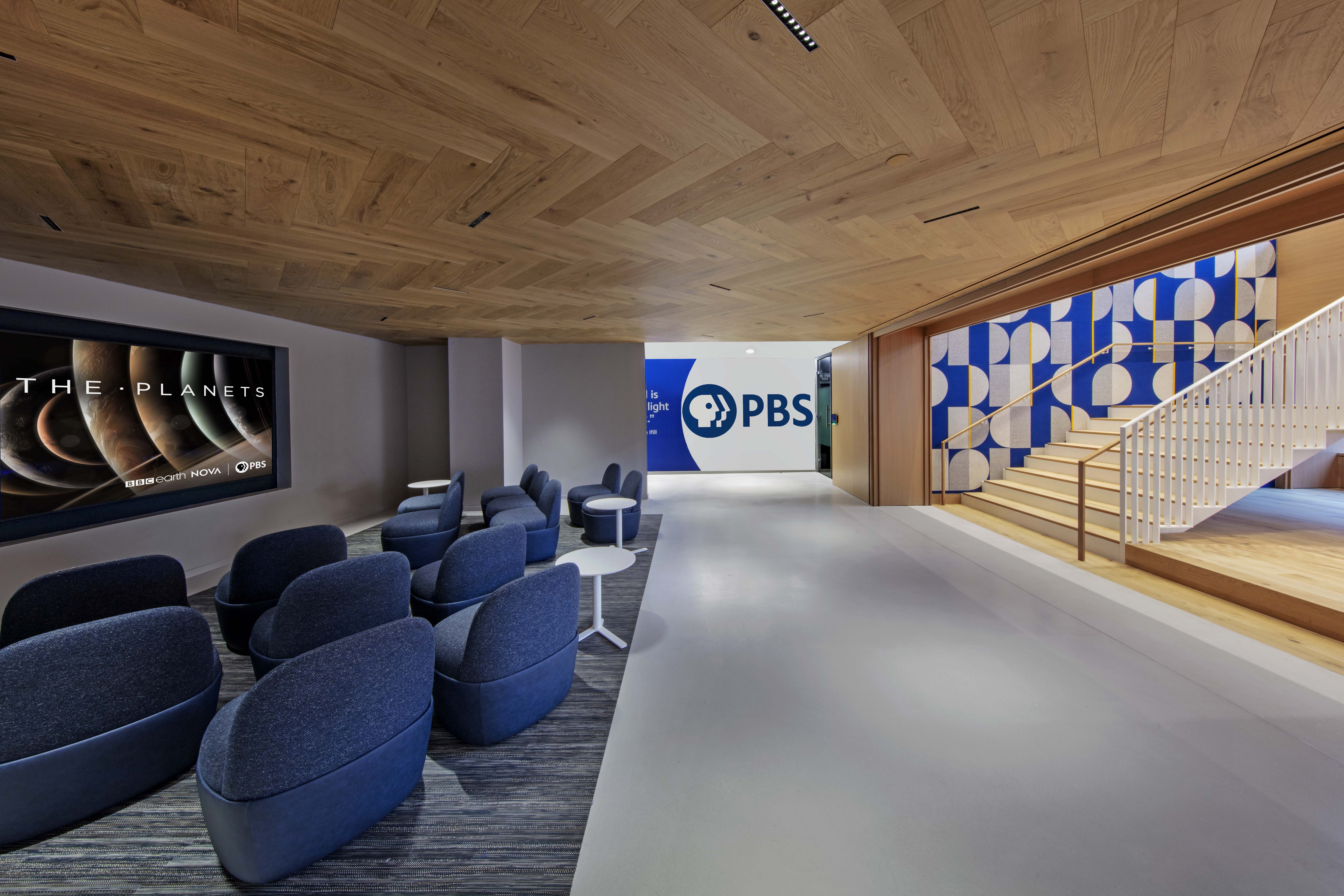 Full size wall next to a staircase at PBS headquarters. The felt wall is covered in a custom design of rectangle and half circle shapes in blue and gray with yellow accents