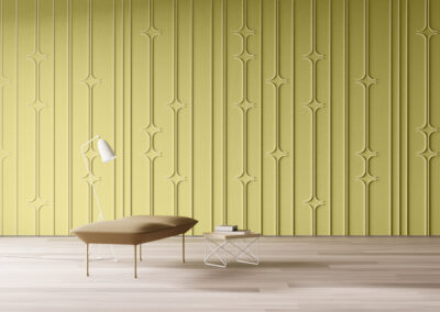 A room with a chartreuse felt wall with vertical lines that occasionally curve horizontally to create sparkles. In front of the wall is a lamp, bench, and small table with books.