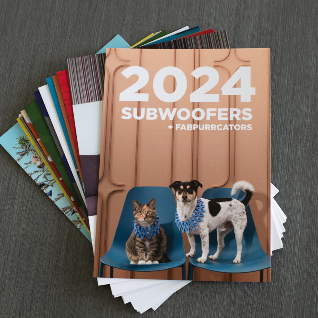 the cards of the 2024. subwoofer calendar are slightly fanned out on a gray tabletop